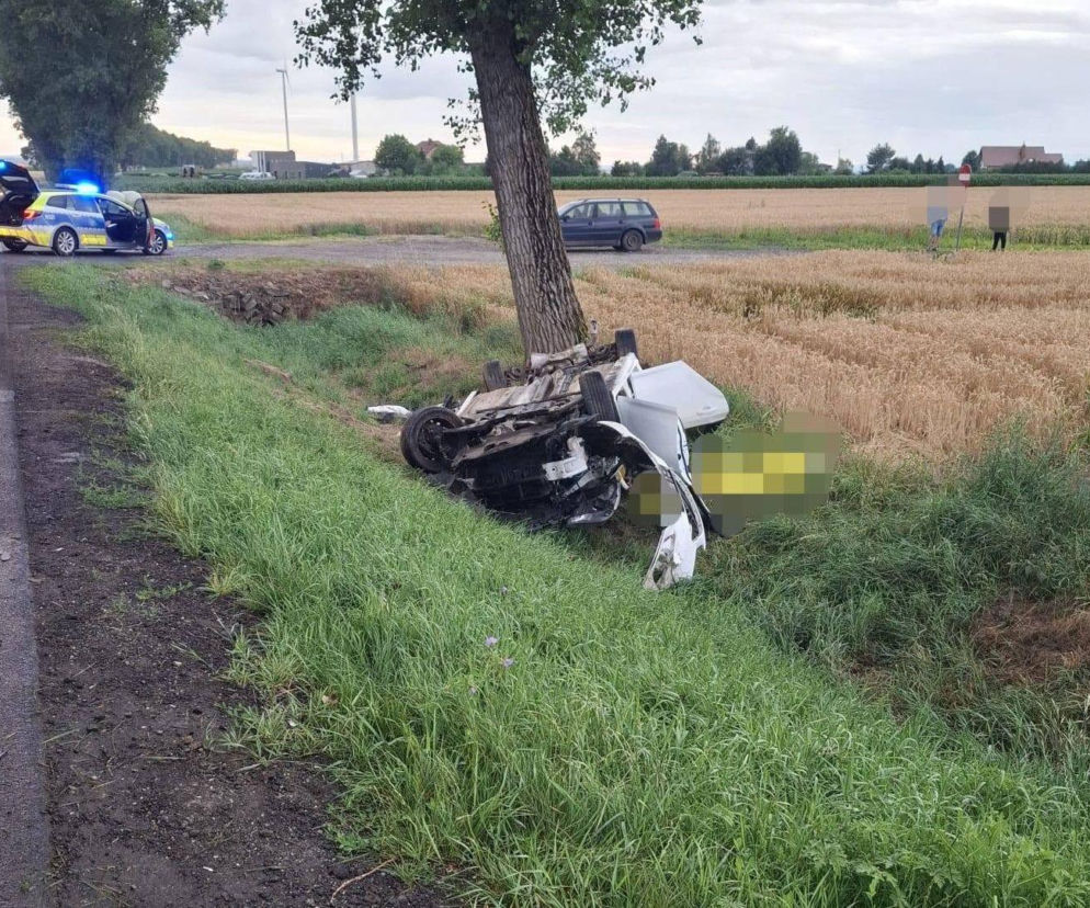Rozbite, białe auto leży w rowie przy drzewie. W tle policja. O wypadku w Żerdzinach przeczytasz na Eska Śląskie.