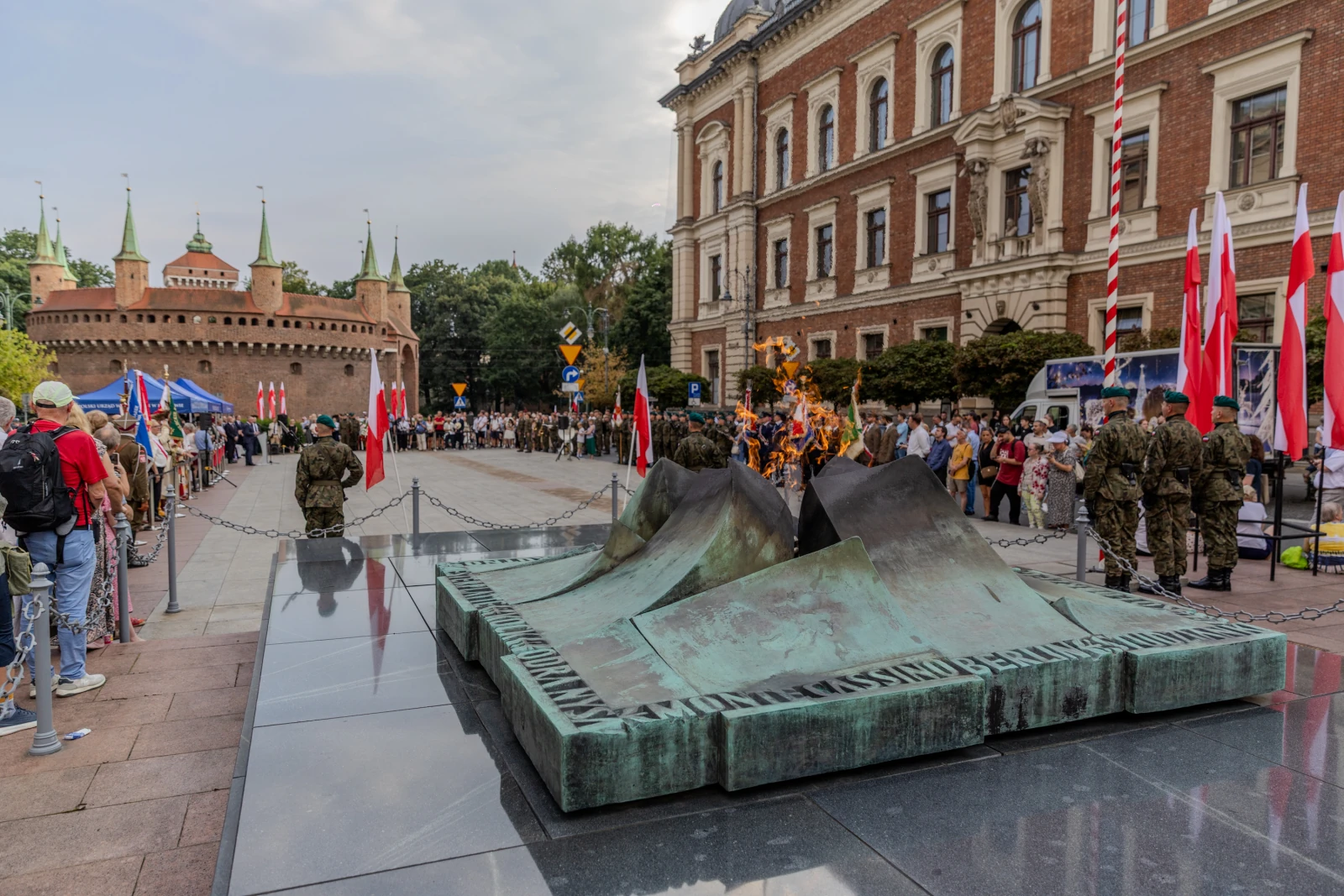 Pomnik z wiecznym ogniem, tłum ludzi, flagi, zamek w tle. Autor: Bogusław Świerzowski
