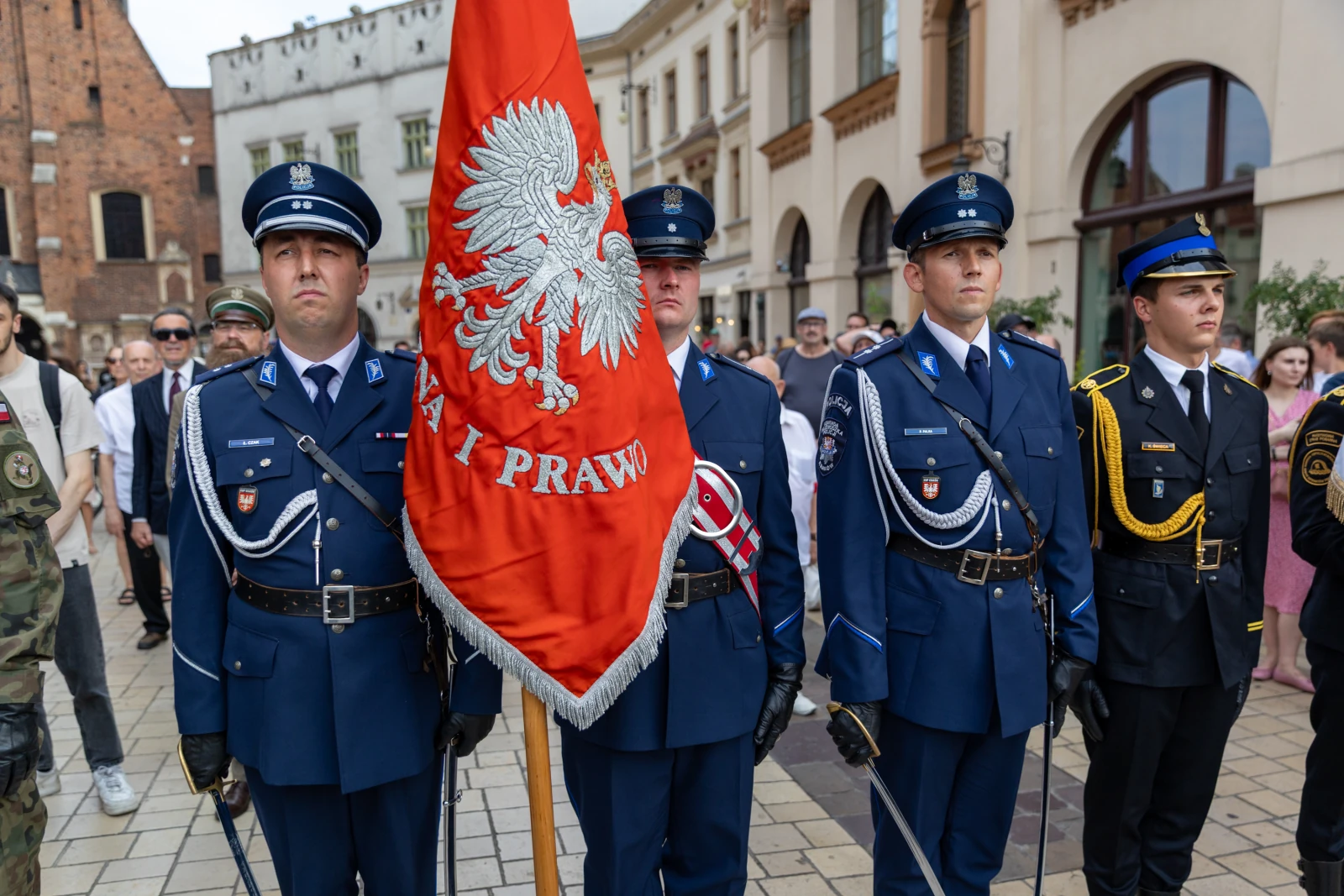 Czterech mężczyzn w mundurach, trzymających flagę z orłem, podczas uroczystości. Autor: Bogusław Świerzowski