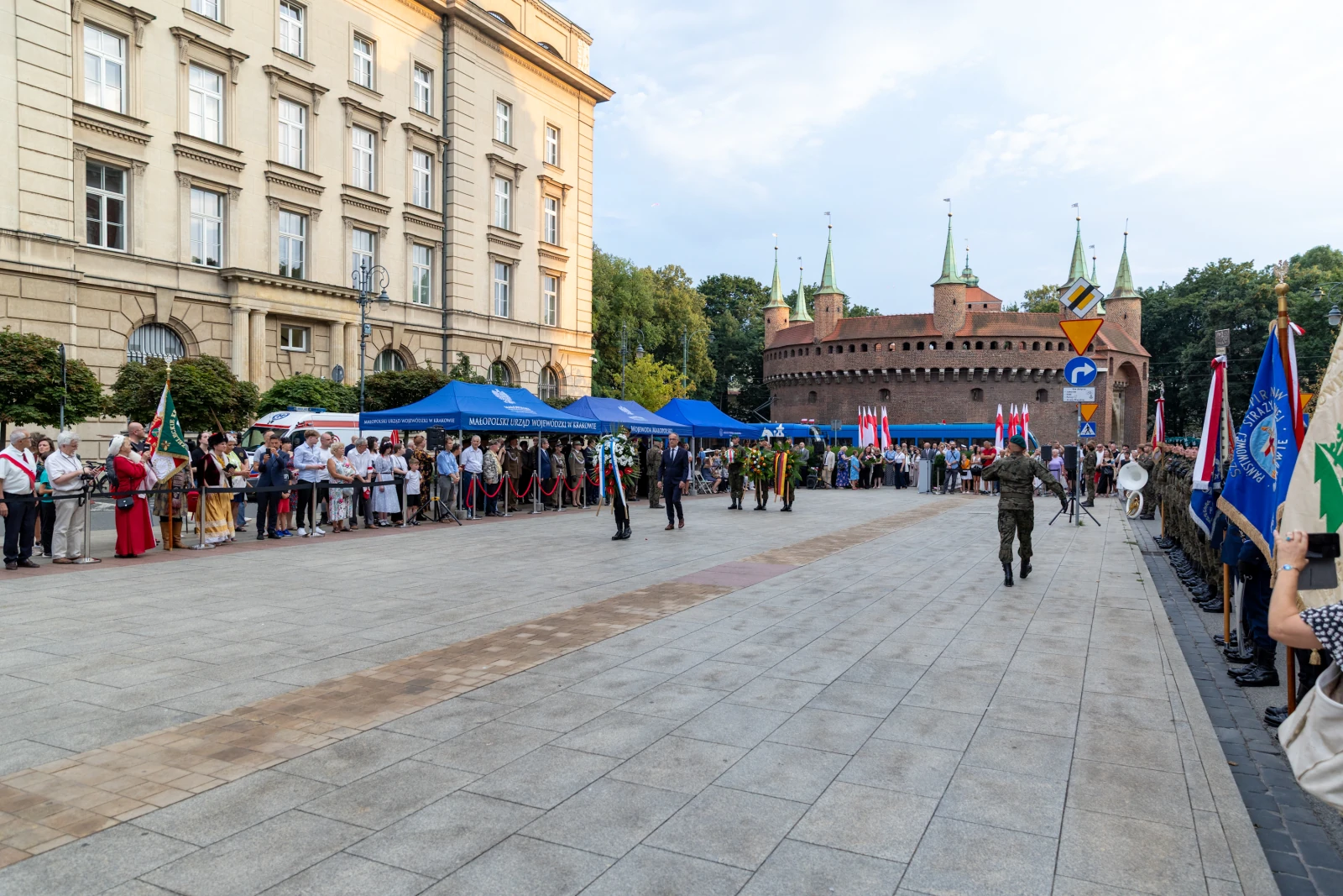 Ceremonia z udziałem żołnierzy, flagi i tłum ludzi przed zamkiem. Autor: Bogusław Świerzowski