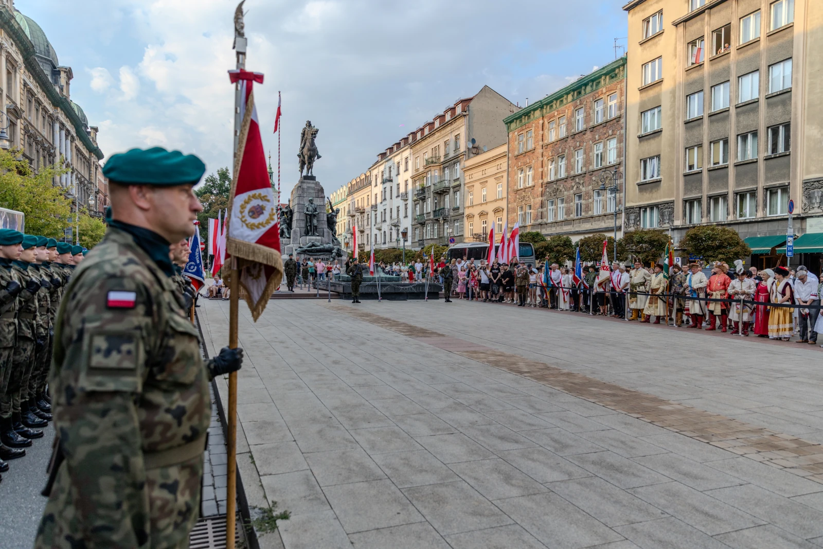 Ceremonia z udziałem żołnierzy, flagi i tłum ludzi na ulicy. Autor: Bogusław Świerzowski