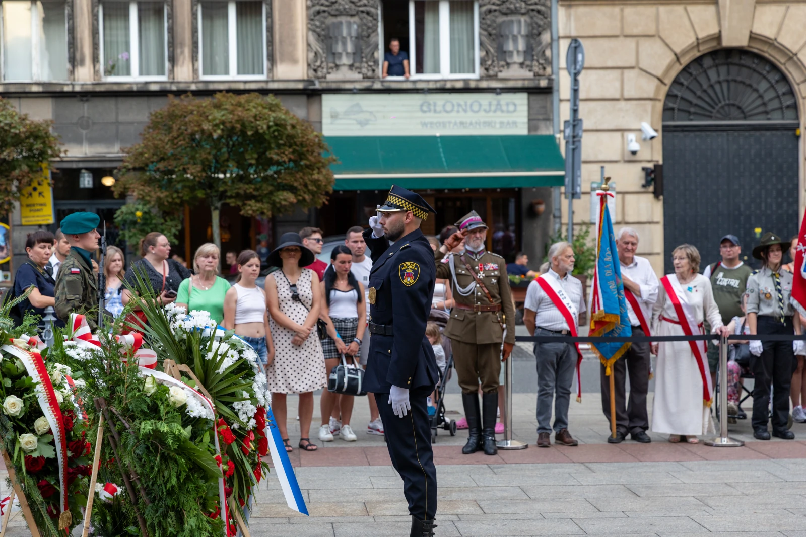 Ceremonia złożenia wieńca przez strażnika w towarzystwie zgromadzonych ludzi. Autor: Bogusław Świerzowski
