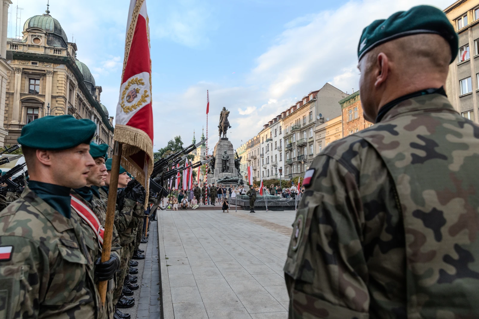 Żołnierze w mundurach wojskowych podczas ceremonii z pomnikiem w tle. Autor: Bogusław Świerzowski