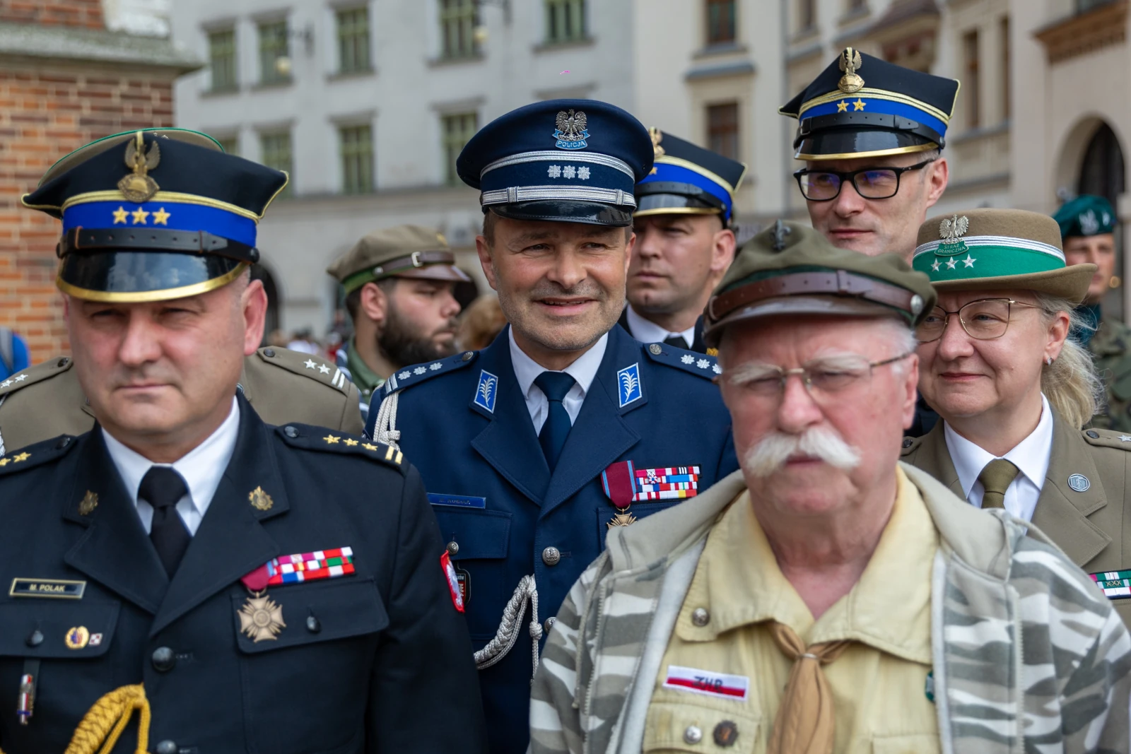 Grupa mężczyzn i kobiet w mundurach wojskowych i policyjnych, z odznaczeniami, podczas uroczystości. Autor: Bogusław Świerzowski