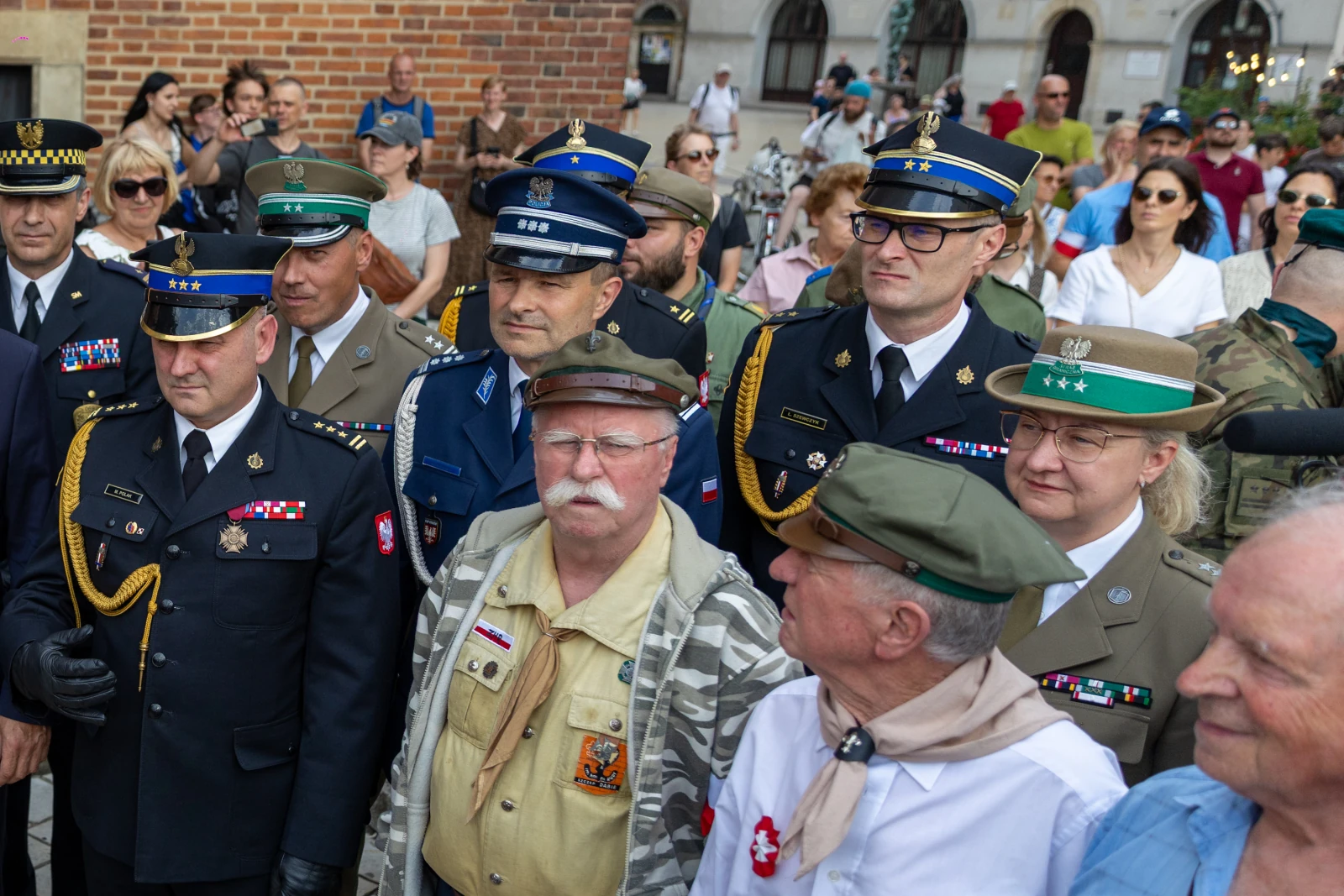 Grupa mężczyzn i kobiet w mundurach wojskowych i policyjnych, uczestniczących w wydarzeniu publicznym. Autor: Bogusław Świerzowski