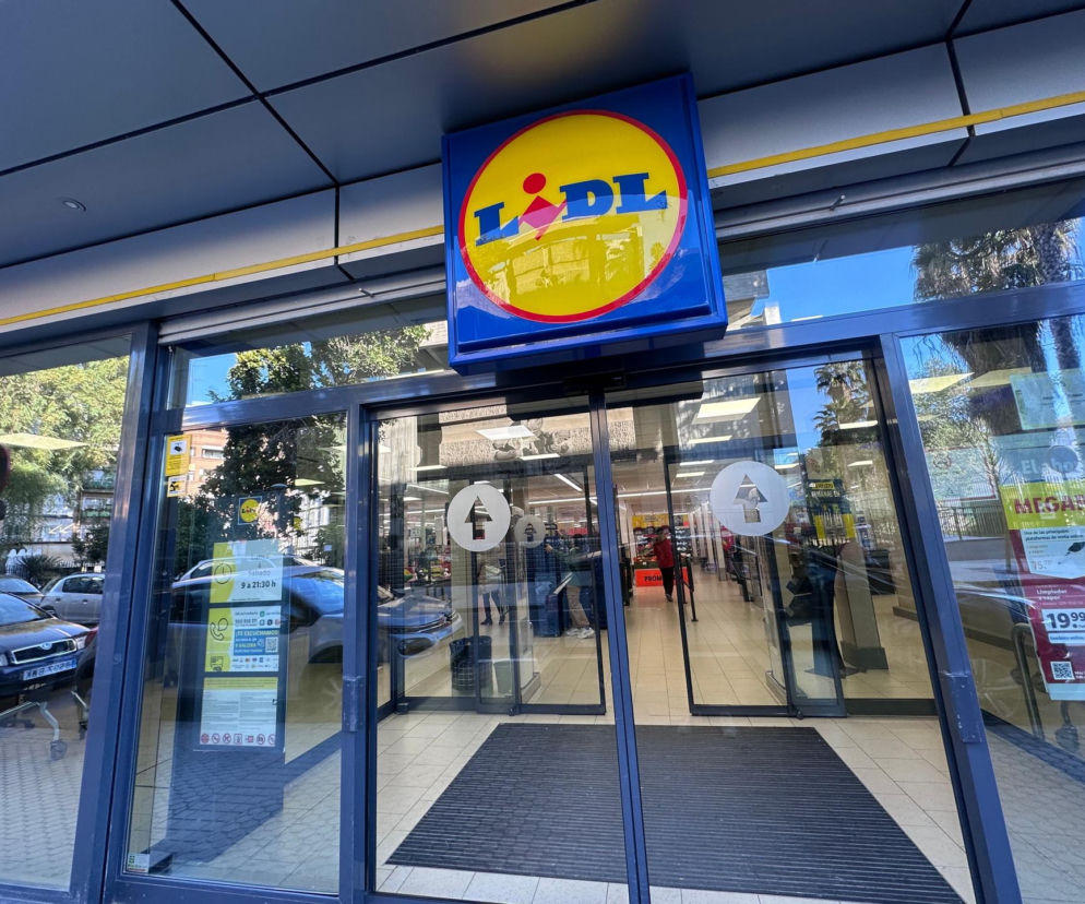 Szklane wejście do marketu Lidl z widocznym logo nad drzwiami. O zarobkach pracowników sieci przeczytasz na Eska Lublin.