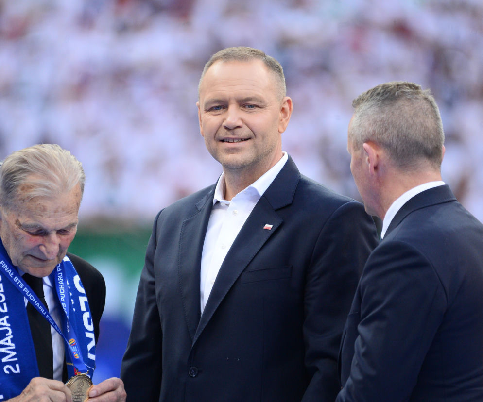 Karol Nawrocki w garniturze stoi obok mężczyzny z medalem. O ułaskawieniu lidera kibiców przeczytasz na Eska.