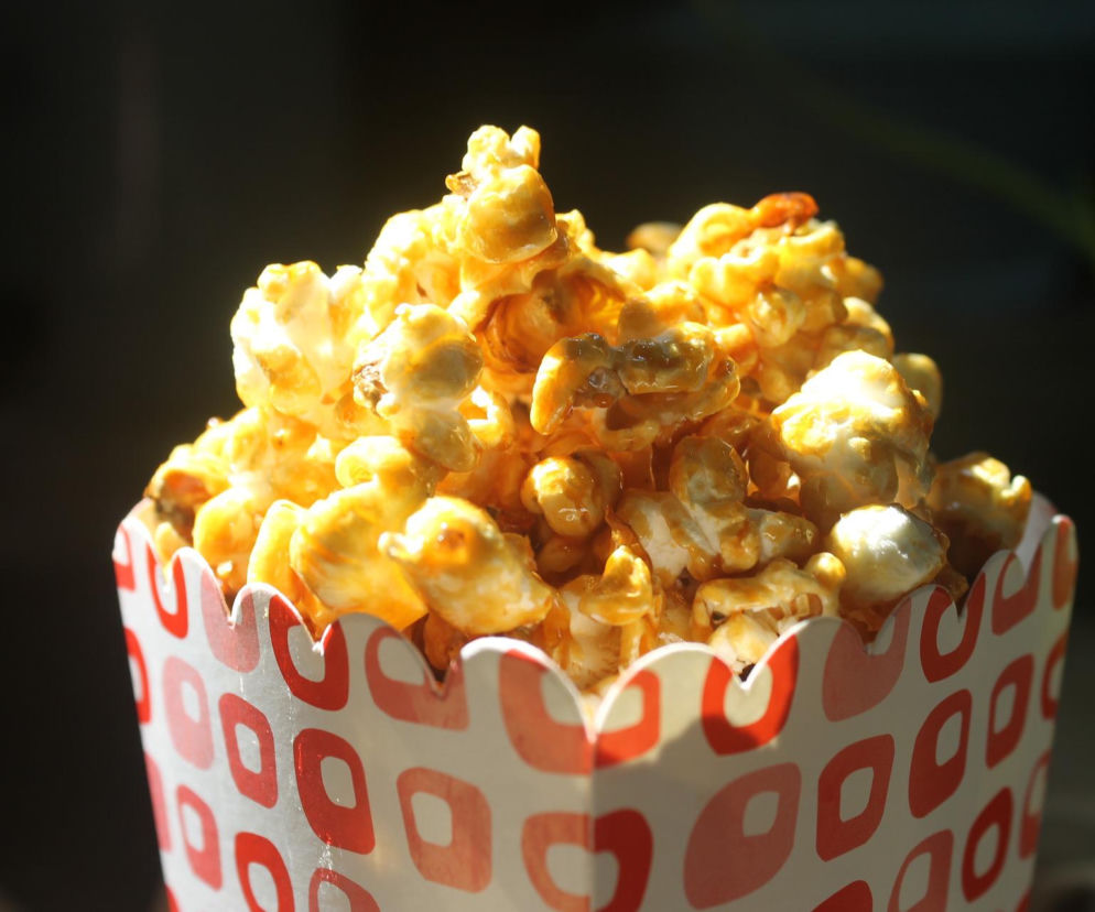 Pudełko słodkiego popcornu w karmelu. O letnim kinie plenerowym na Osiedlu Łużyckim przeczytasz na Radioplus.