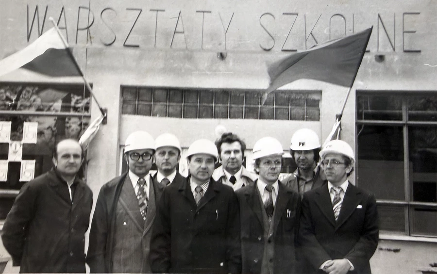 Przed budynkiem warsztatów szkolnych stoją od lewej: Jan Głombik, Tadeusz Bugała, Gerard Tomala, Kazimierz Komarnicki, Stefan Hlubek, Lucjan Zielonka, Ryszard Chrobok, Tadeusz Małecki.