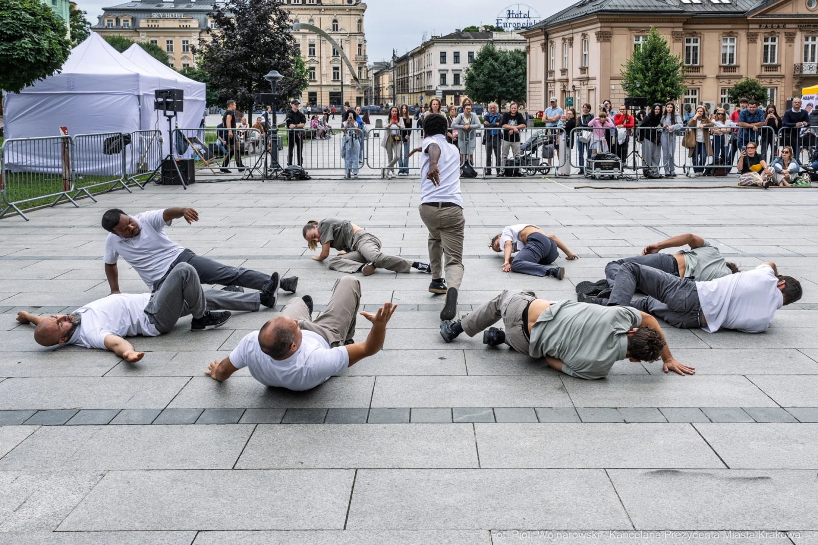 Grupa tancerzy wykonujących choreografię na placu, widownia obserwująca z boku. Autor: Piotr Wojnarowski