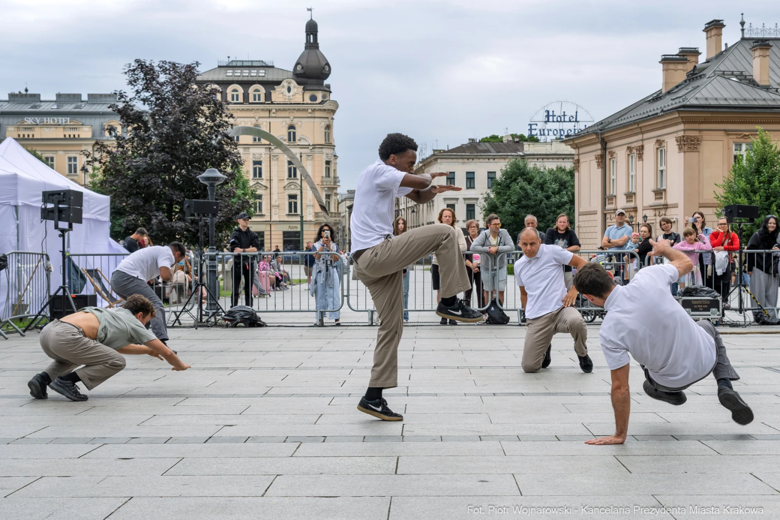 Grupa tancerzy wykonujących choreografię na placu w mieście. Autor: Piotr Wojnarowski