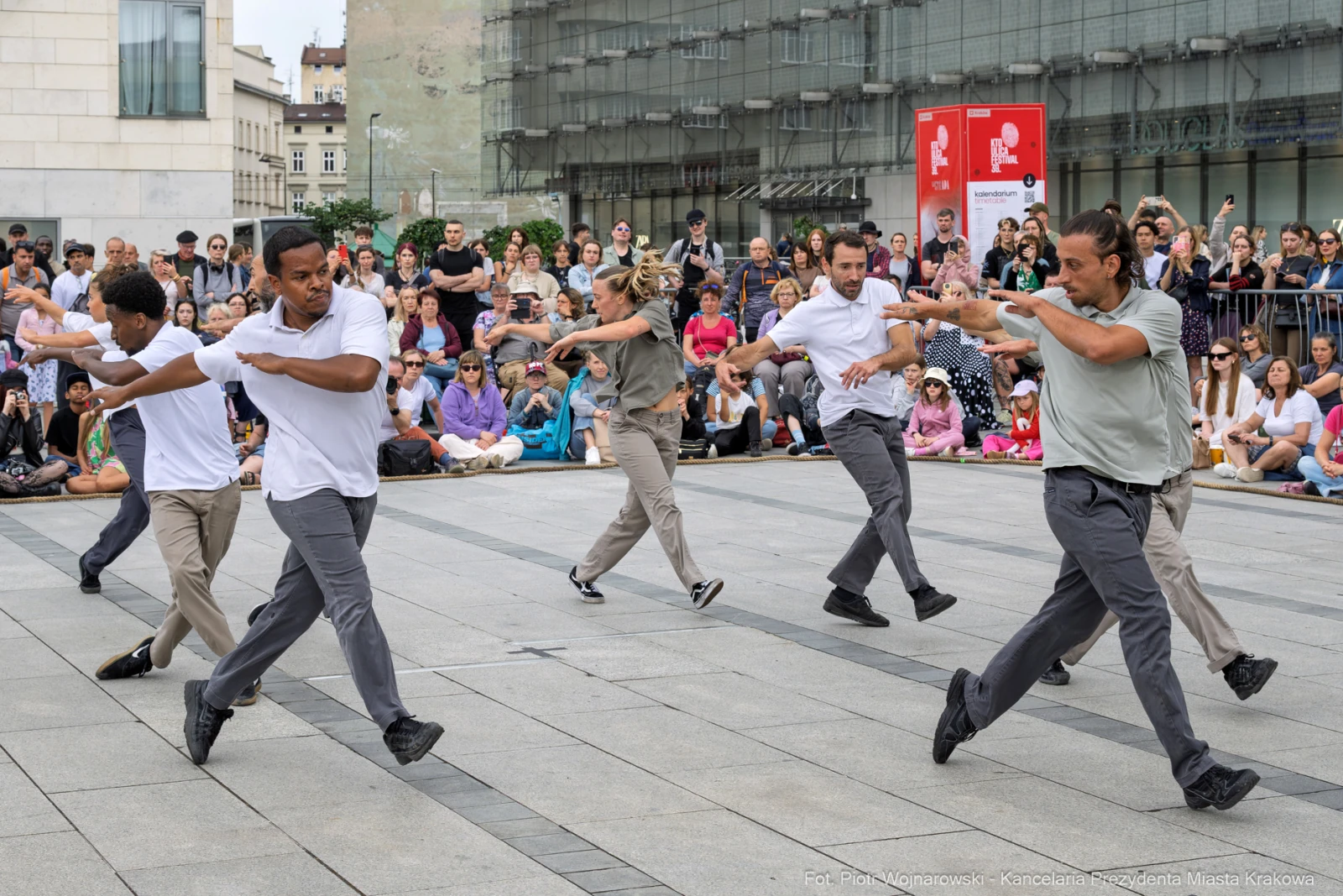 Grupa tancerzy wykonujących choreografię na placu wśród widowni. Autor: Piotr Wojnarowski