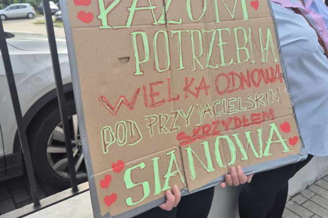 Osoba trzymająca transparent popierający gminę Sianów podczas protestu, o którym przeczytasz na Radioplus.