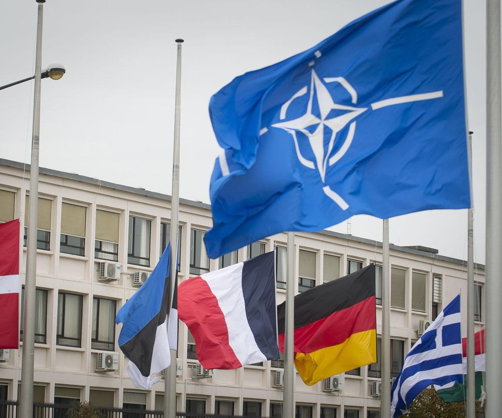 Flaga NATO powiewa przed budynkiem obok flag państw członkowskich. O szczycie w Ankarze przeczytasz na Radioplus.