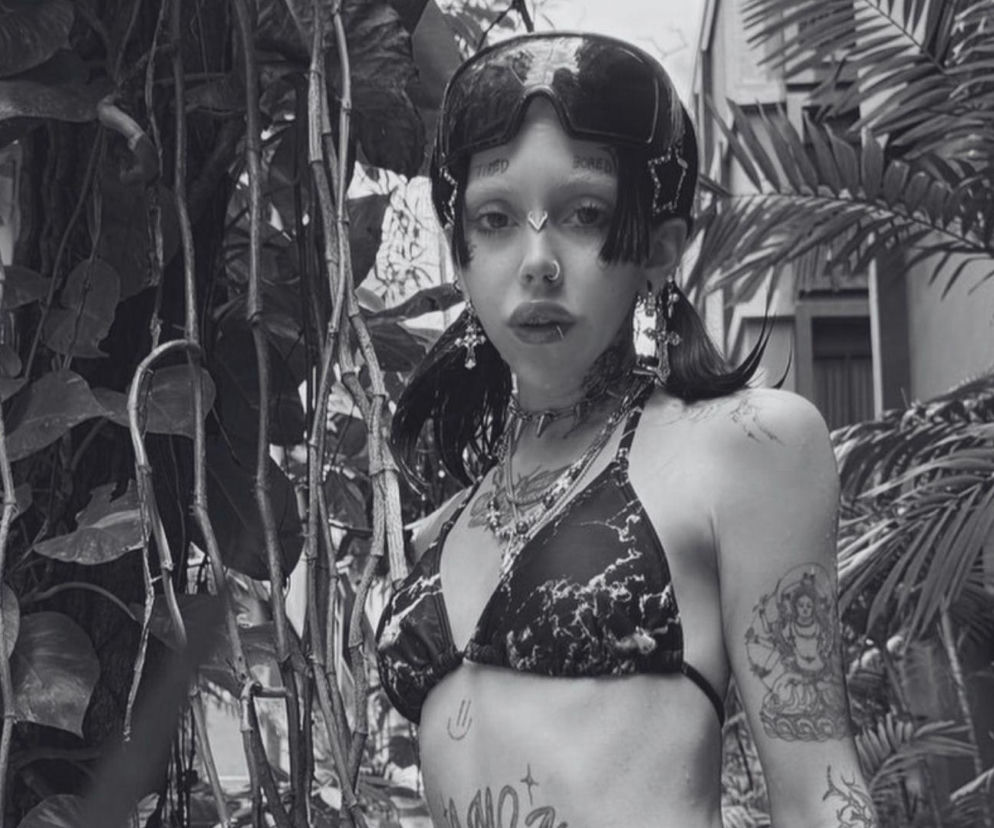 Wytatuowana influencerka Łapa Hapa w czarnym bikini i goglach na tle roślin. O jej śmierci przeczytasz na Eska.