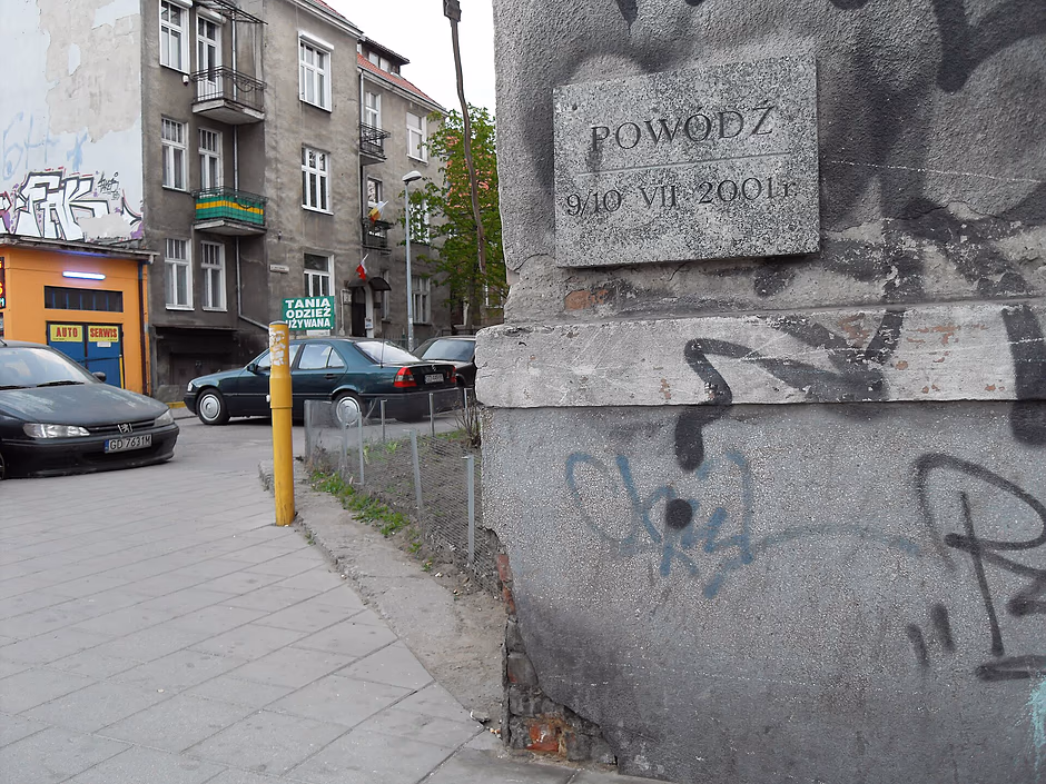 Tablica na elewacji budynku z napisem "powódź".