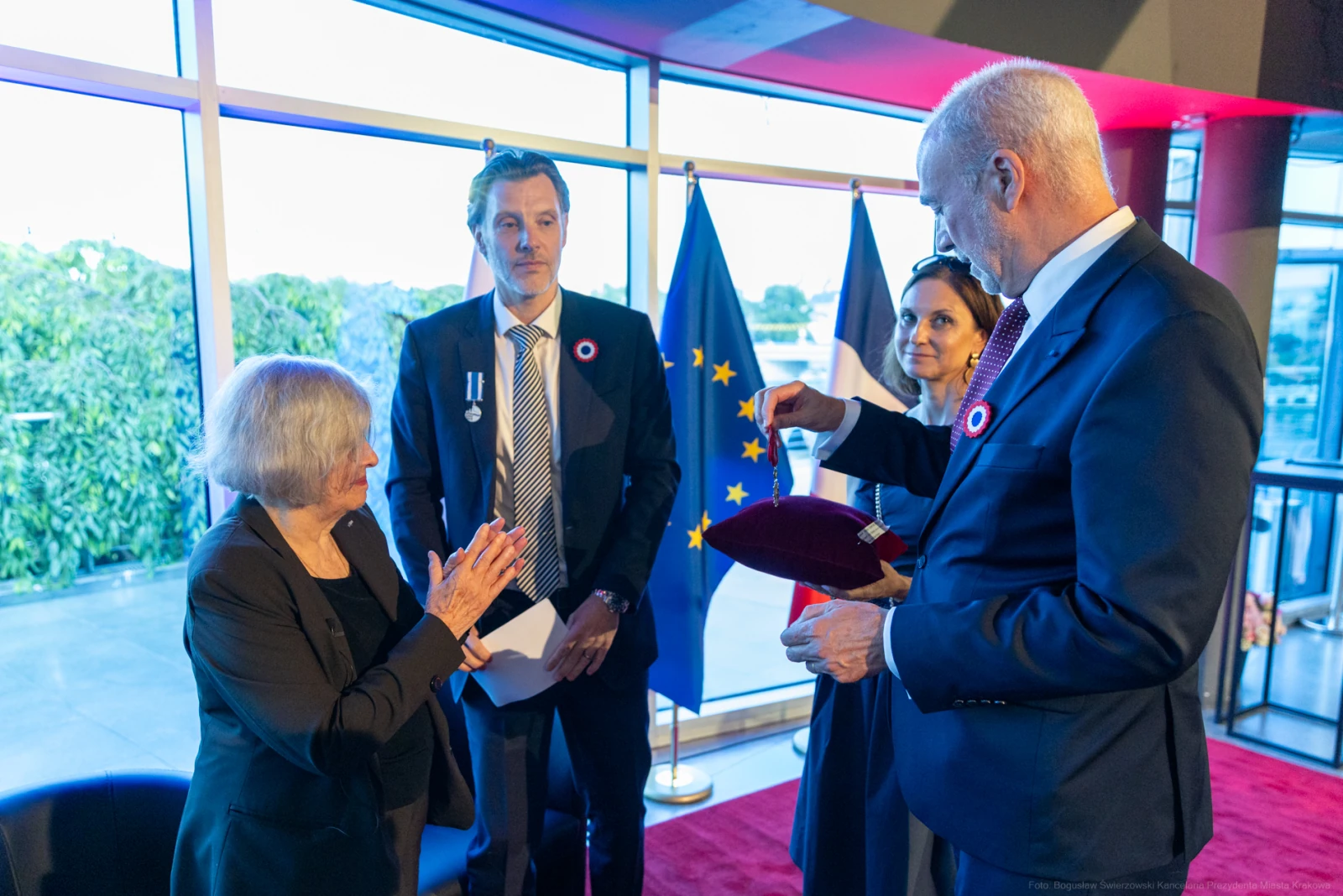 Ceremonia wręczenia odznaczeń w obecności flagi Francji i Unii Europejskiej. Autor: Bogusław Świerzowski
