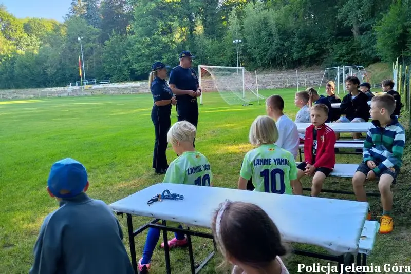 Policjantka i strażnik miejski edukują dzieci o bezpieczeństwie podczas wakacji