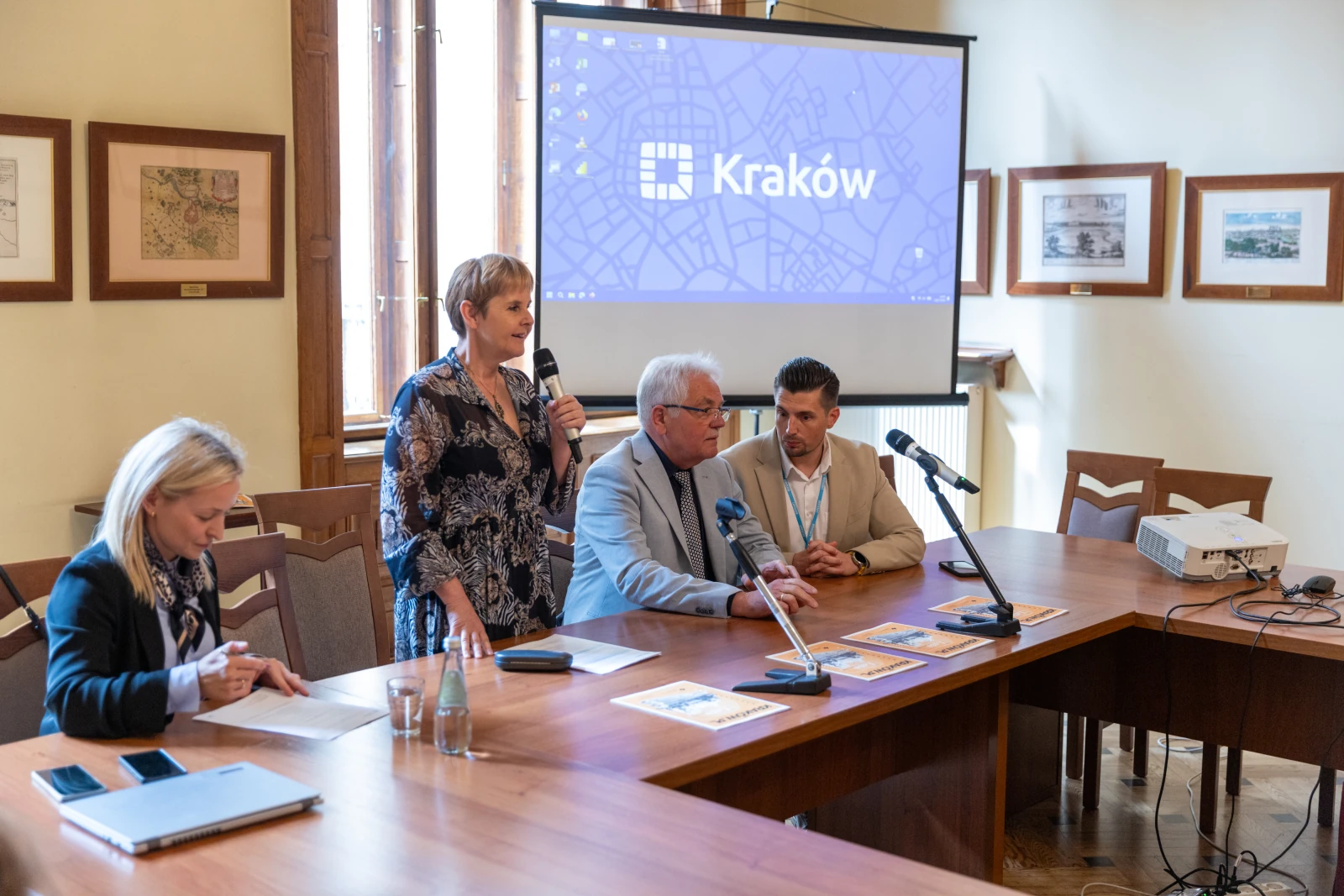 Konferencja w Krakowie, prelegenci przy stole, prezentacja na ekranie. Autor: Bogusław Świerzowski
