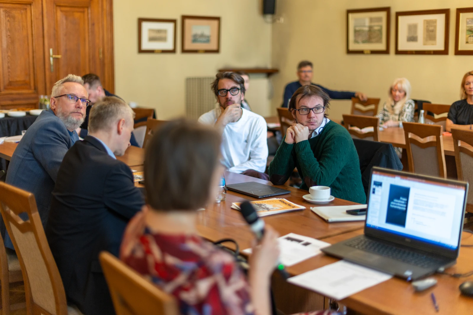 Grupa ludzi uczestniczy w dyskusji przy stole w sali konferencyjnej. Autor: Bogusław Świerzowski