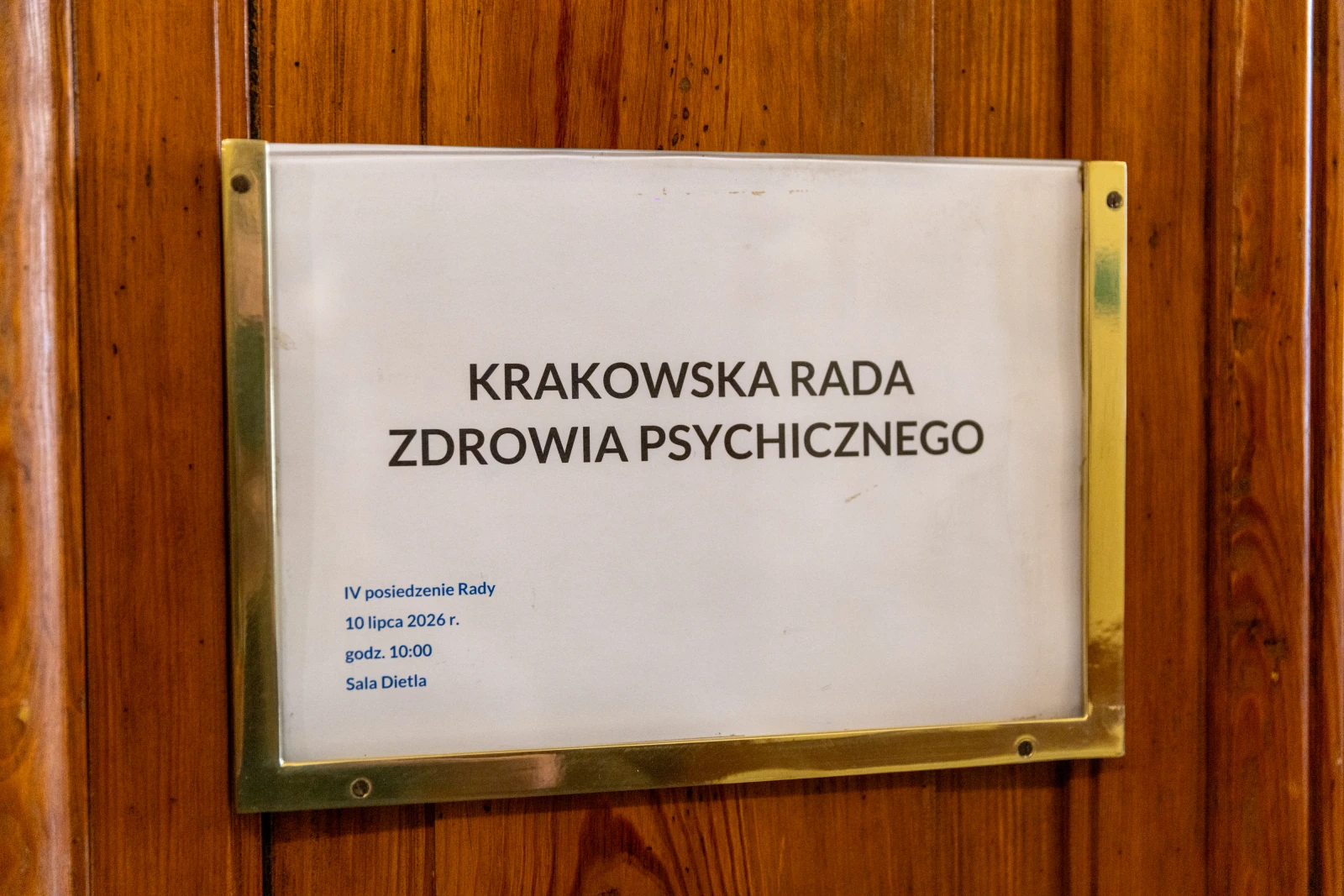 Tablica informacyjna Krakowskiej Rady Zdrowia Psychicznego z datą i godziną posiedzenia. Autor: Bogusław Świerzowski