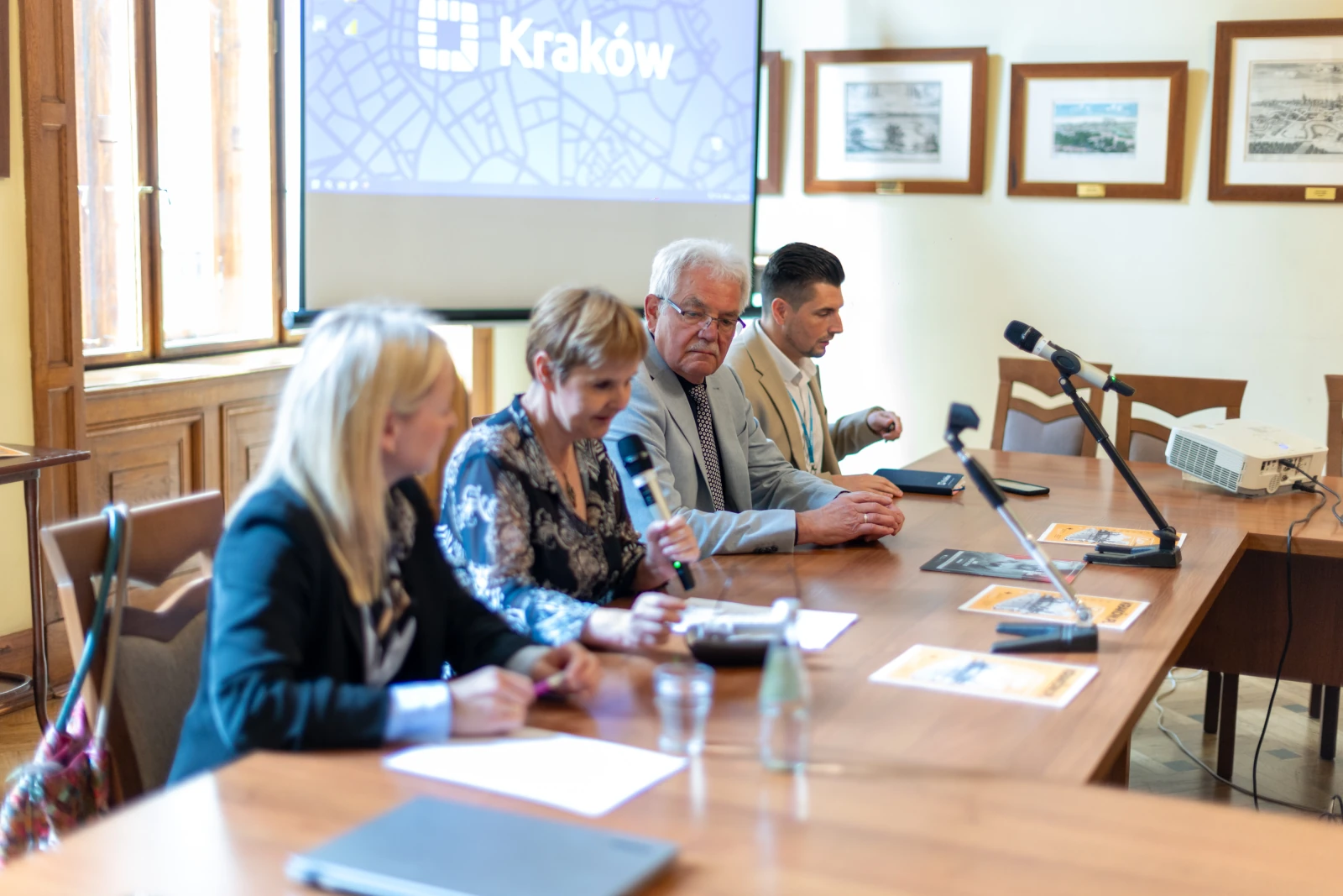 Konferencja w Krakowie z czterema prelegentami przy stole, prezentacja w tle. Autor: Bogusław Świerzowski