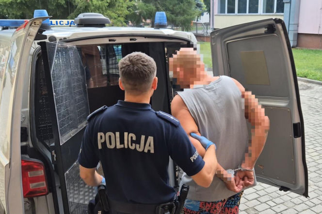 Policjant wprowadza do radiowozu zatrzymanego mężczyznę w kajdankach. O akcji w Firlejach przeczytasz na Radioplus.