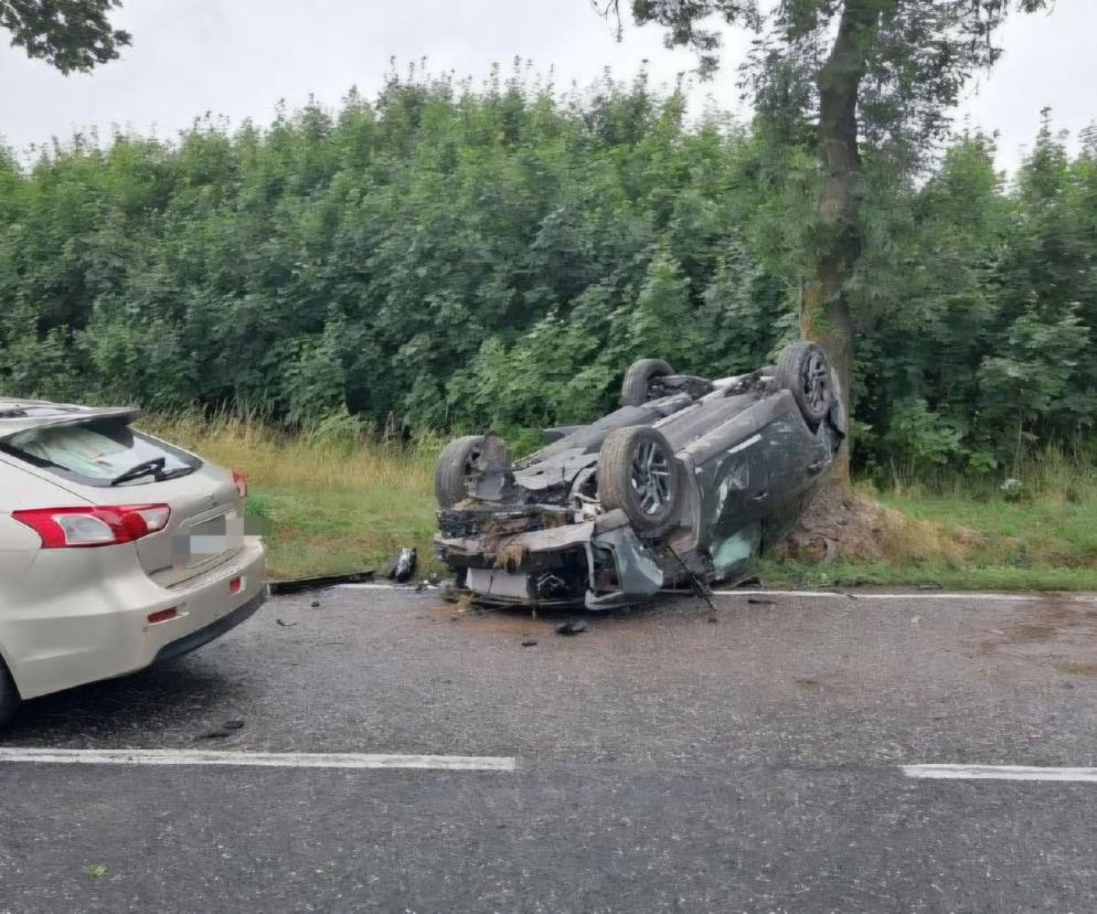 Zniszczony samochód leży na dachu przy drzewie na poboczu. O wypadku w Skorzeszycach przeczytasz na Eska Kielce.