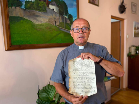 Ksiądz Ryszard Piwowarczyk prezentujący znalezisko, które wzbogaci archiwum parafii przed ponownym umieszczeniem na wieży.