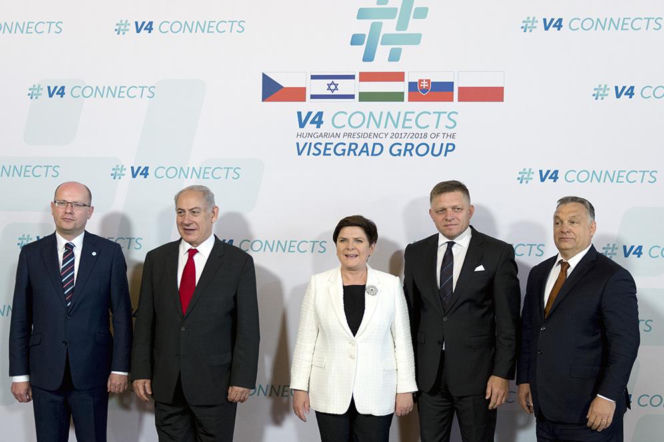 Premier Słowacji Robert Fico w grupie liderów państw na tle logo Grupy Wyszehradzkiej. O polityce Ficy czytaj w Radioplus.