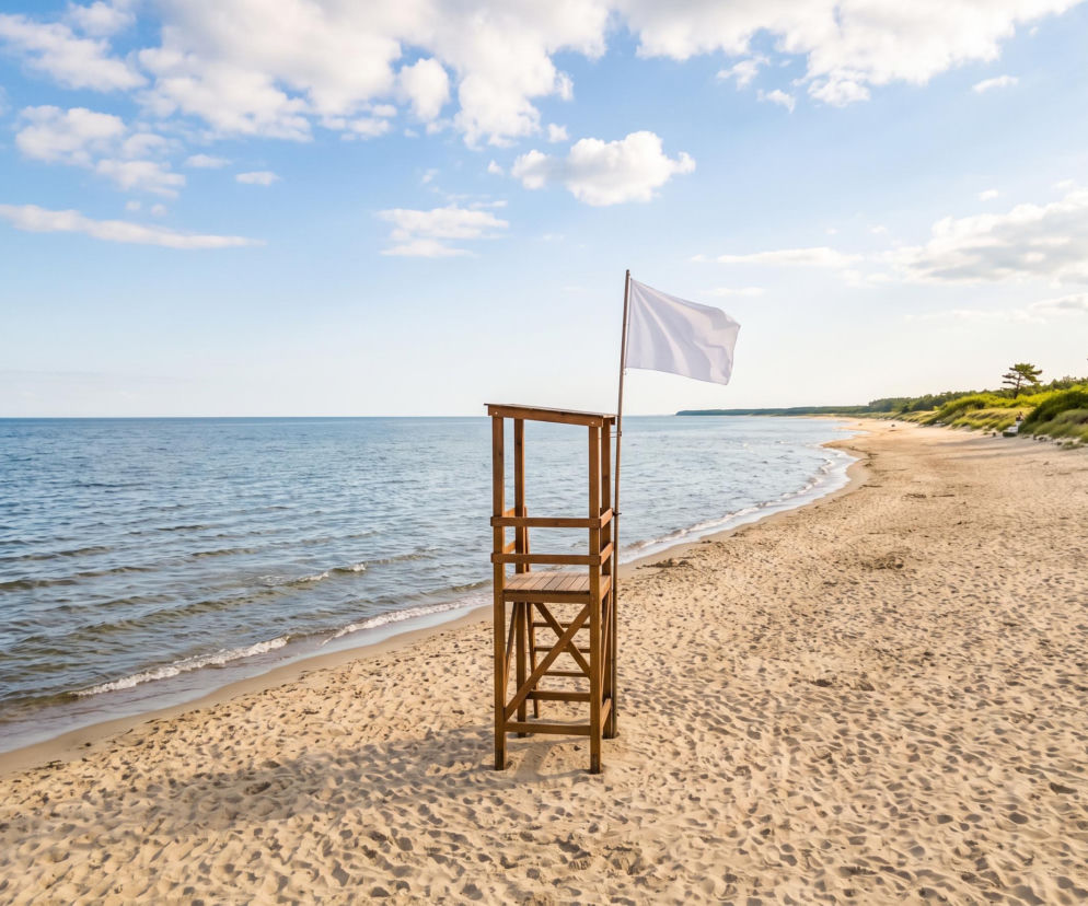 Biała flaga na wieży ratowniczej na pustej plaży w Chałupach. O braku sinic przeczytasz na Eska Trójmiasto.