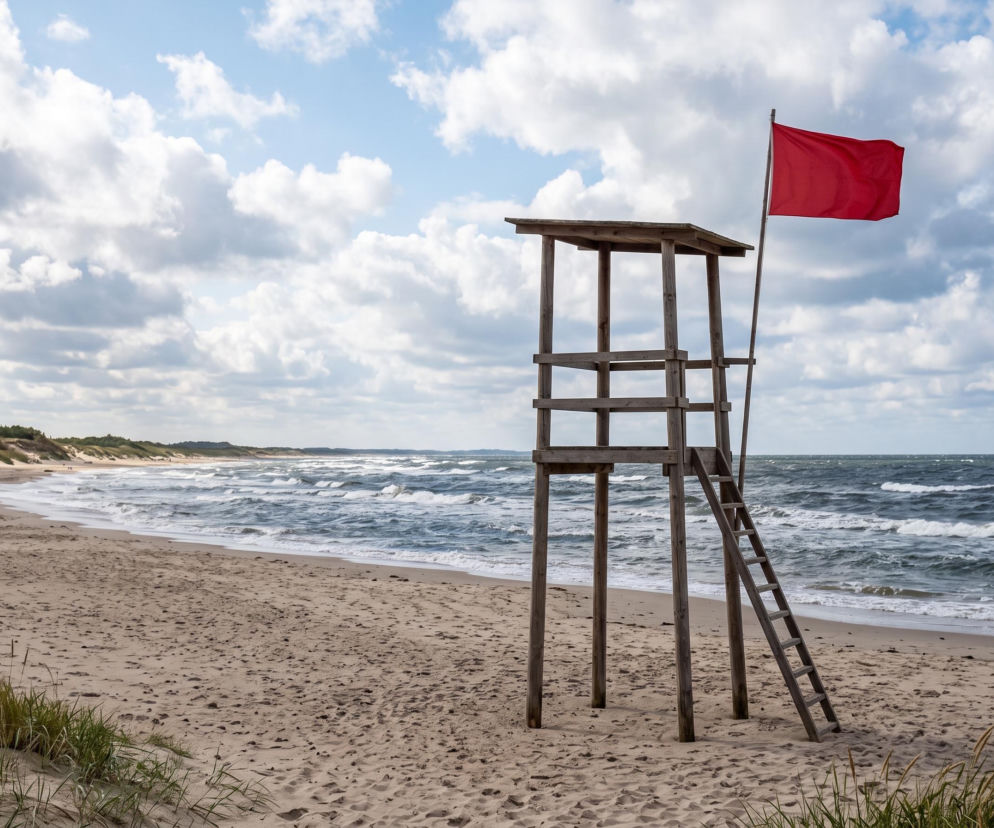 Wieża ratownicza z czerwoną flagą na pustej plaży w Chałupach. O zakazie kąpieli przeczytasz na Eska Trójmiasto.