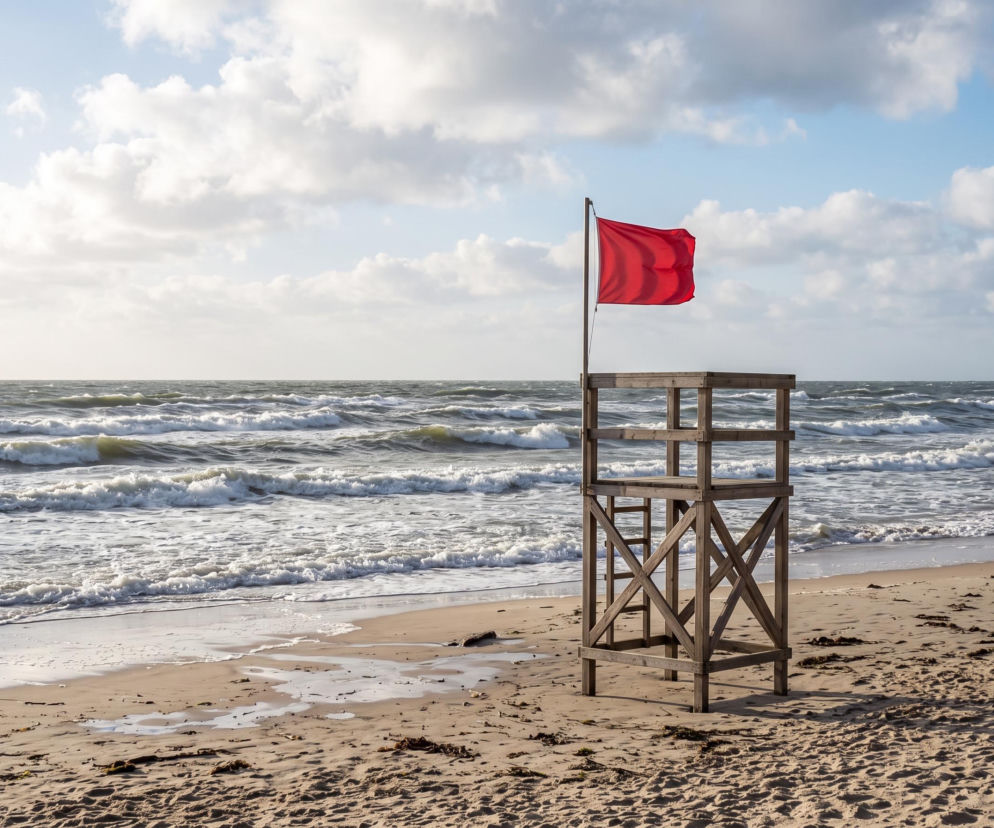 Czerwona flaga na wieży ratowniczej nad wzburzonym morzem. O zakazie kąpieli w Chałupach przeczytasz na Eska Trójmiasto.