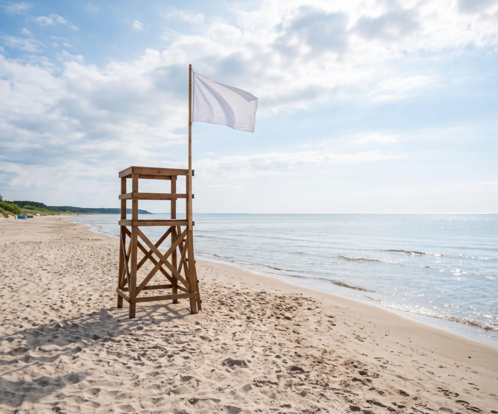 Biała flaga na wieży ratowniczej nad brzegiem morza w Chłopach. O bezpiecznej kąpieli przeczytasz na SE Szczecin.