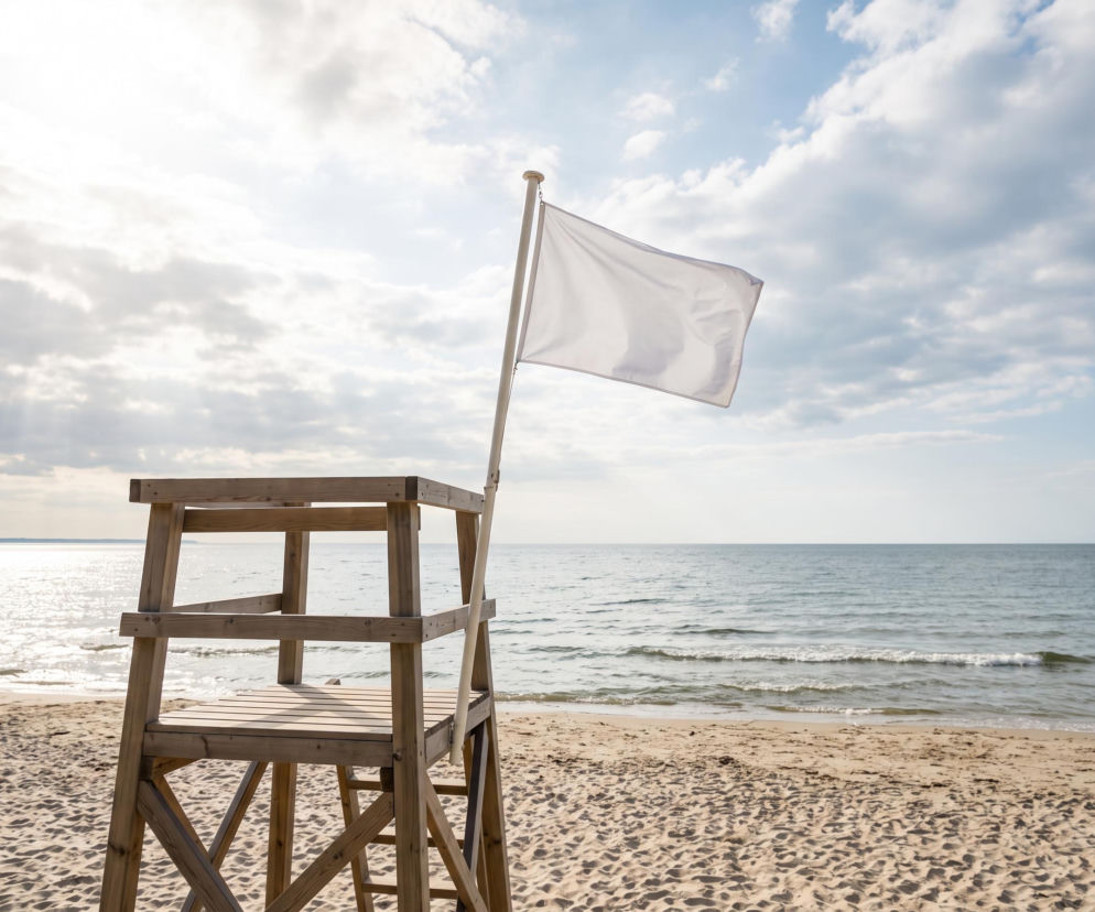 Biała flaga na wieży ratowniczej na plaży w Gdańsku. O czystości wody w kąpieliskach przeczytasz na Eska Trójmiasto.