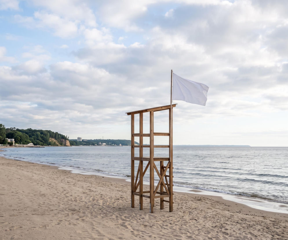 Drewniana wieża ratownicza z białą flagą na plaży w Gdyni. O bezpieczeństwie kąpieli przeczytasz na Eska Trójmiasto.