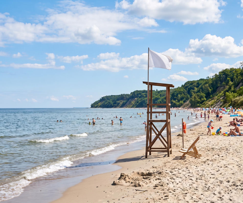 Plaża w Jastrzębiej Górze z białą flagą na wieży ratowniczej. O braku sinic przeczytasz na Eska Trójmiasto.