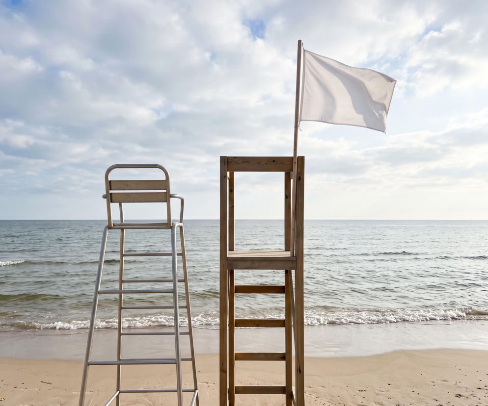 Dwie wieże ratownicze na plaży w Jastrzębiej Górze. Na jednej powiewa biała flaga. O bezpieczeństwie pisze Eska Trójmiasto.