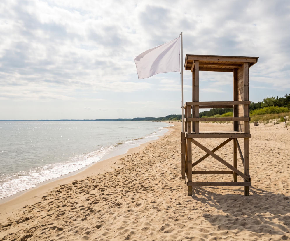 Drewniana wieża ratownicza z białą flagą na plaży w Mechelinkach. O bezpieczeństwie kąpieli przeczytasz na Eska Trójmiasto.