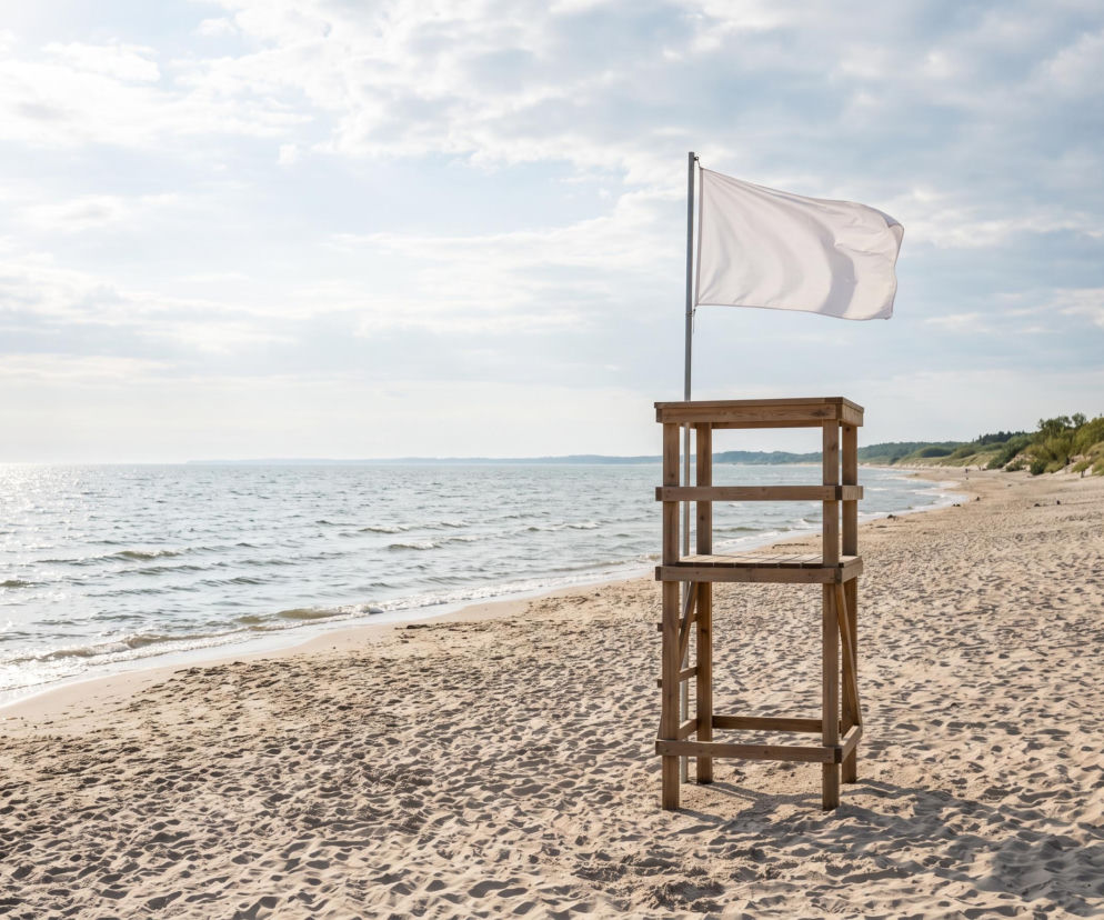 Biała flaga na wieży ratowniczej na pustej plaży w Rewie. O bezpiecznych kąpielach przeczytasz na Eska Trójmiasto.