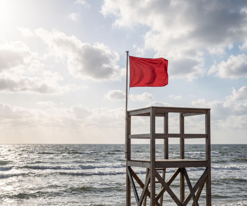 Czerwona flaga na wieży ratowniczej przy wzburzonym morzu. O zamkniętych plażach w Rowach przeczytasz na Eska Trójmiasto.