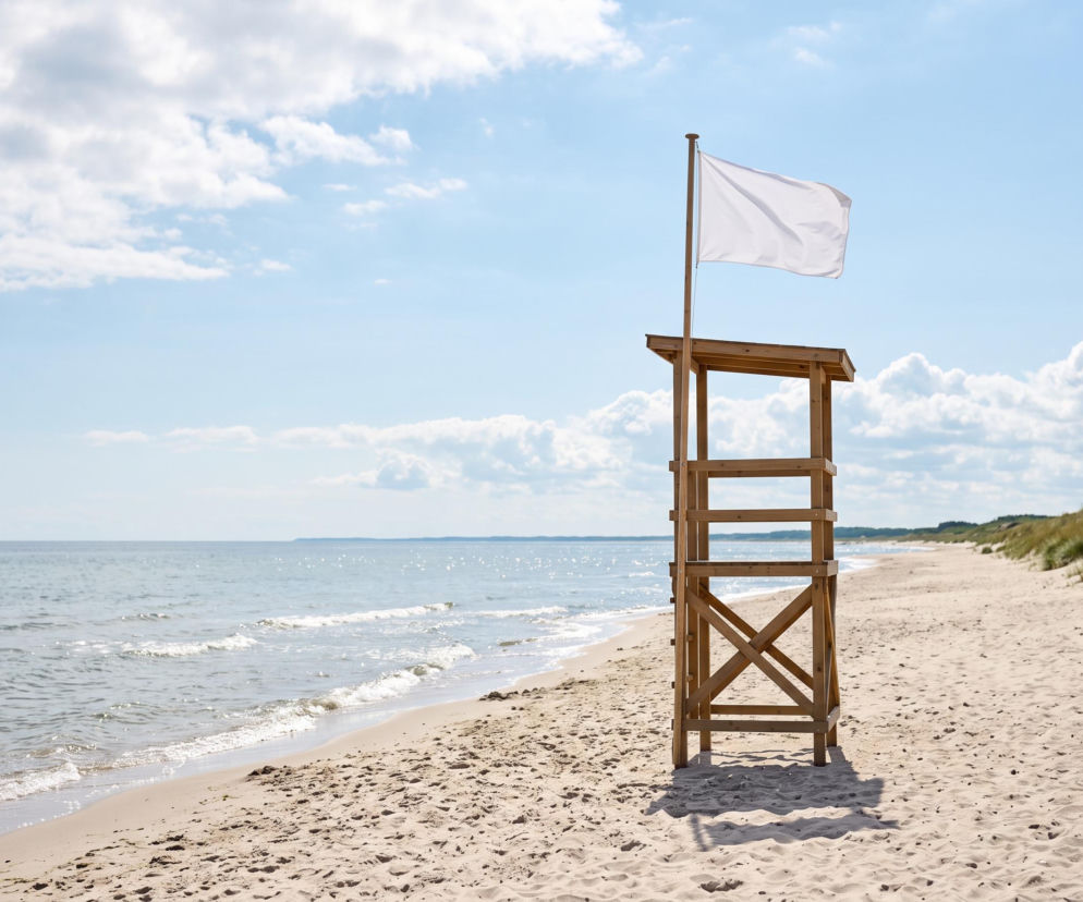 Biała flaga na wieży ratowniczej na pustej plaży w Rowach. O bezpiecznych kąpieliskach przeczytasz na Eska Trójmiasto.