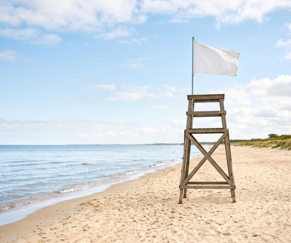 Biała flaga na wieży ratowniczej na pustej plaży. O bezpiecznej kąpieli w Sopocie przeczytasz na Eska Trójmiasto.