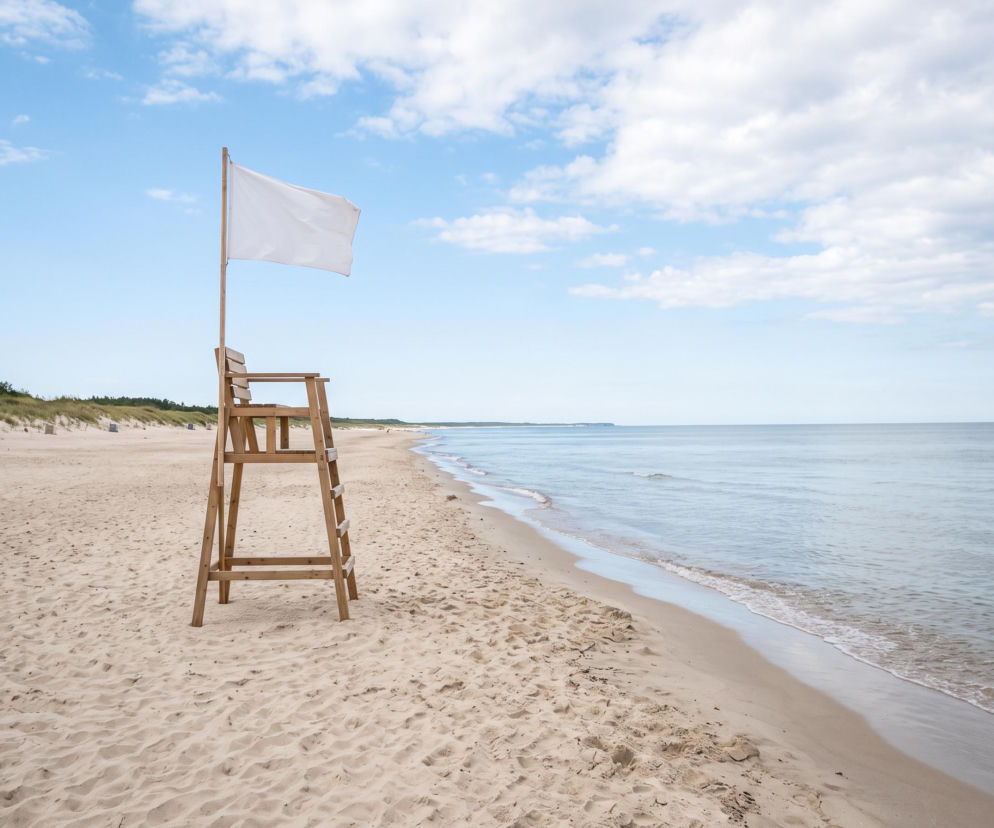Drewniana wieża ratownicza z białą flagą na pustej plaży we Władysławowie. O pogodzie przeczytasz na Eska Trójmiasto.