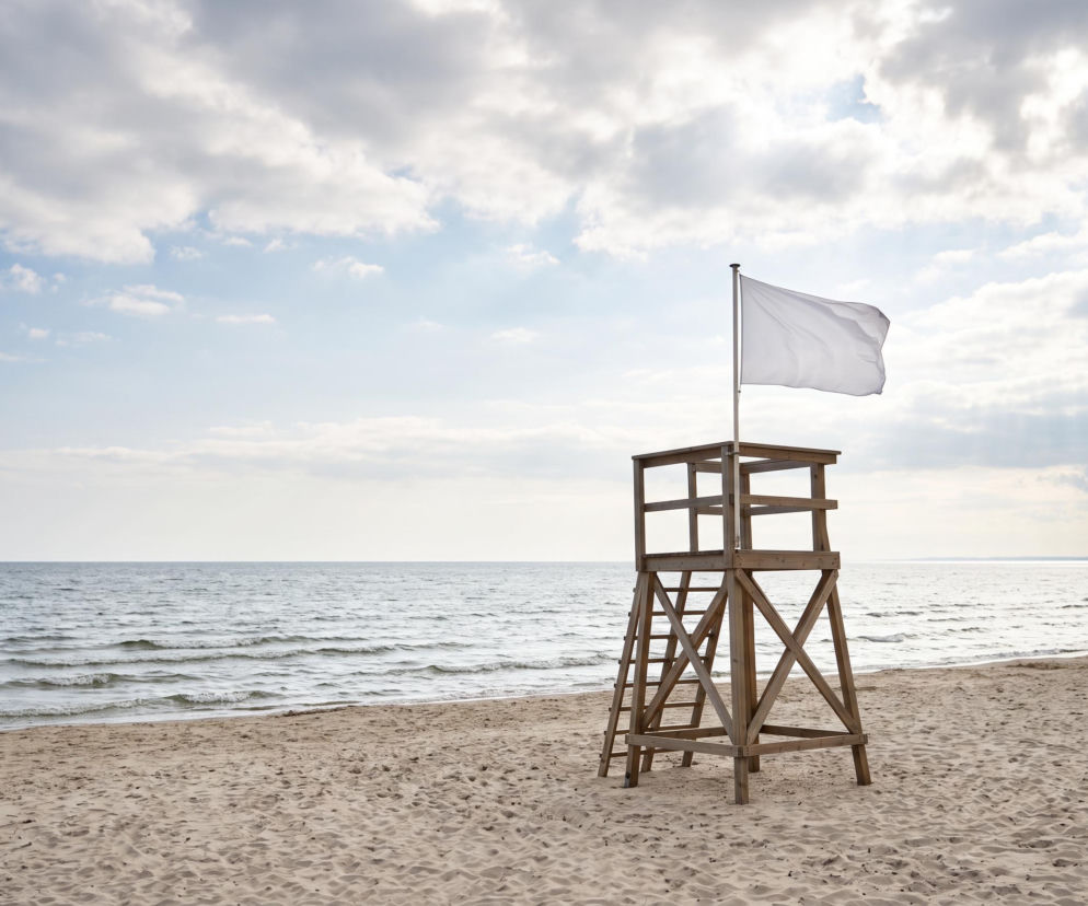 Drewniana wieża ratownika z białą flagą na plaży we Władysławowie. O warunkach do kąpieli przeczytasz na Eska Trójmiasto.