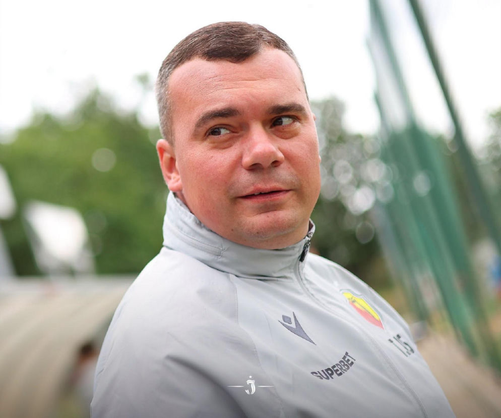 Trener Adrian Siemieniec w szarym dresie sportowym. O sukcesach Jagiellonii Białystok przeczytasz na Eska Białystok.