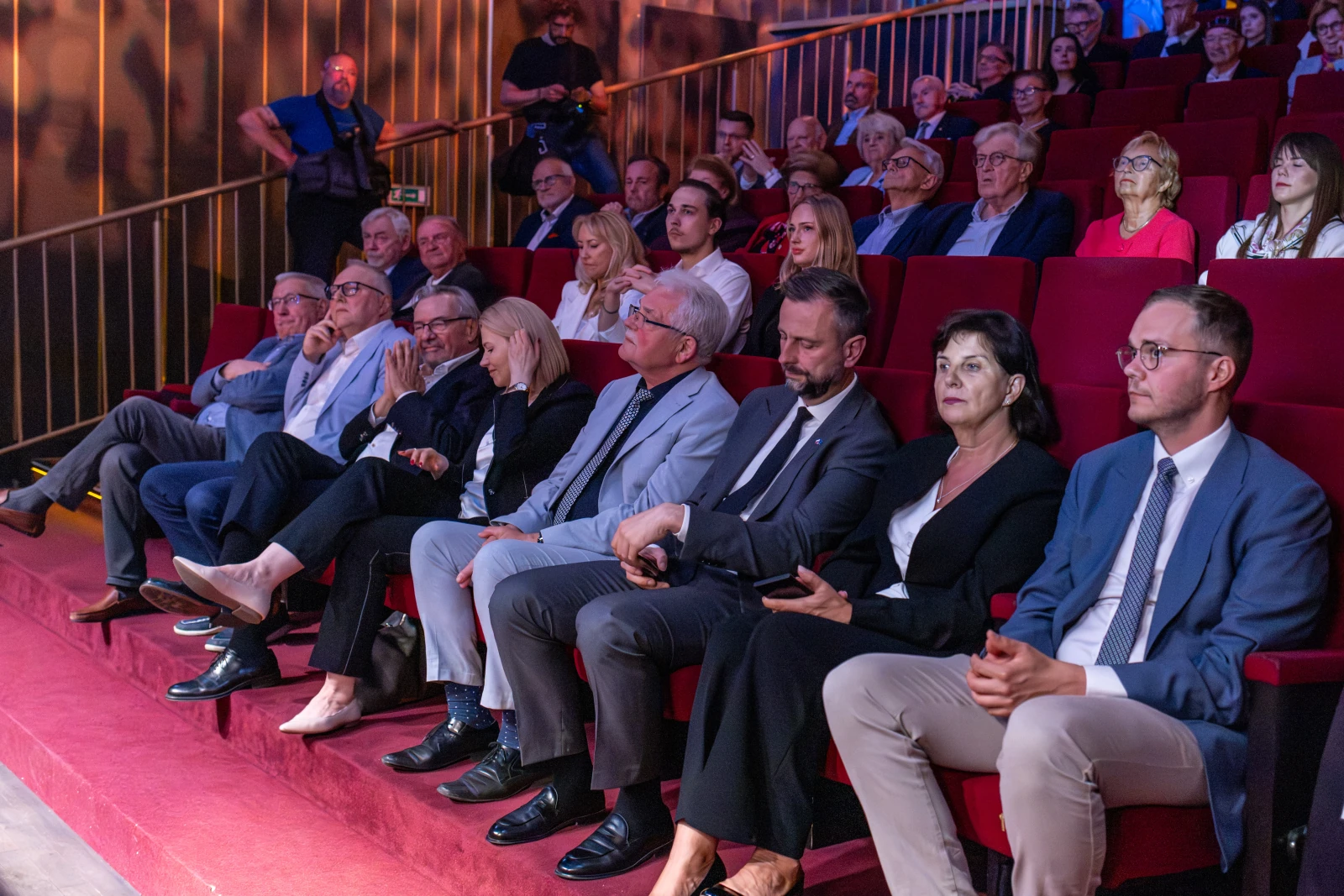 Grupa ludzi siedzących na widowni w teatrze, skupionych na wydarzeniu. Autor: Bogusław Świerzowski