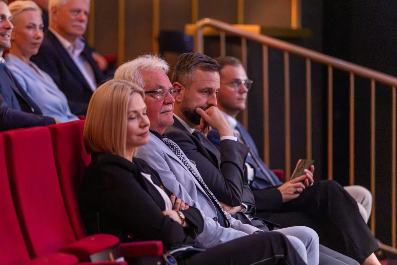 Grupa ludzi siedzących na widowni w teatrze, skupionych na występie. Autor: Bogusław Świerzowski