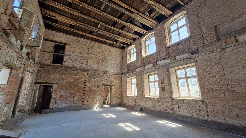 wnętrze remontowanego budynku, widać ceglane ściany