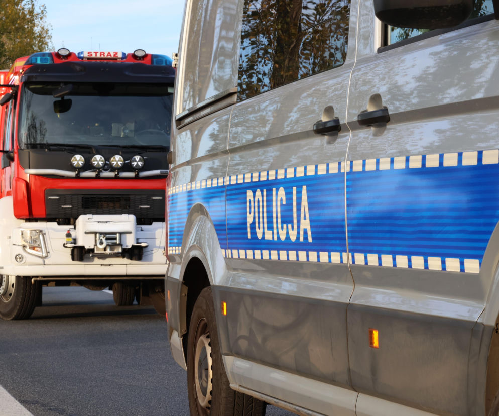 Służby na miejscu wypadku na DK 63. W tle wóz strażacki i radiowozy. O szczegółach zdarzenia przeczytasz na SE Białystok.